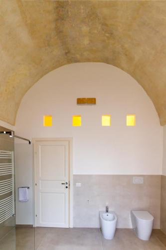 a bathroom with yellow squares on the ceiling at Palazzo Cariddi Apartment in Nardò