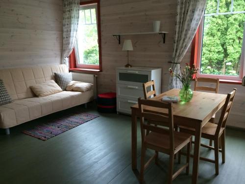 een woonkamer met een tafel en stoelen en een bank bij Guest House Mr Fox in Druskininkai