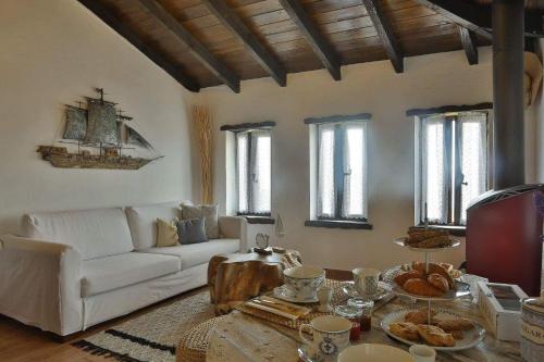 a living room with a white couch and a table at Agkaze in Palaios Panteleimon