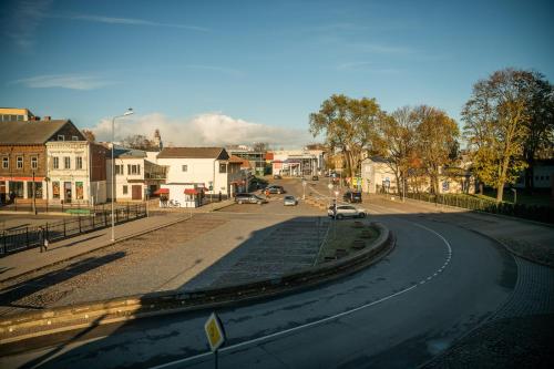 an empty street in a town with cars on the road at Liepaja Apartments in Liepāja
