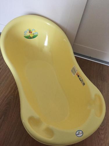a yellow bath tub sitting on top of a wooden floor at Liepaja Apartments in Liepāja