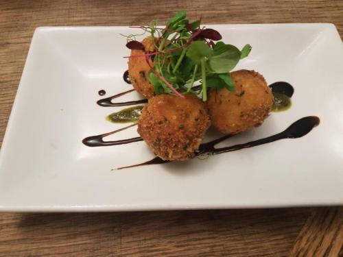 a white plate with some food on a table at The Barge Inn in Bradford on Avon