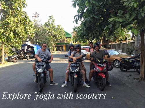 a group of people sitting on motorcycles in the street at OstiC House in Yogyakarta