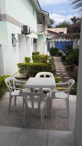 a white table and two chairs on a patio at Kitnets & Flats in Ubatuba