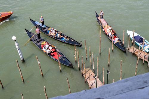a group of people in canoes in the water next to a dock at Hotel Antiche Figure in Venice