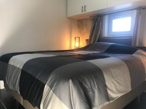 a bedroom with a large bed with a window at Het Kleinste Hof in Geraardsbergen