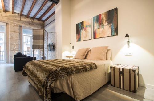 a bedroom with a large bed with a suitcase at Beautiful loft in old town in Alicante