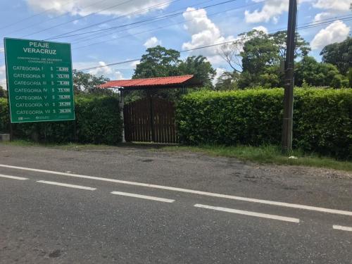a sign on the side of a road with a gate at Finca la Miradita in Cumaral