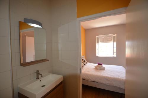 a bathroom with a sink and a bed and a mirror at Dushi Pietermaai Apartments, DPA in Willemstad