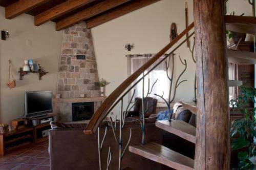 un salon avec un escalier et une cheminée dans l'établissement Entre las Piedras y musgo, à Muñopepe
