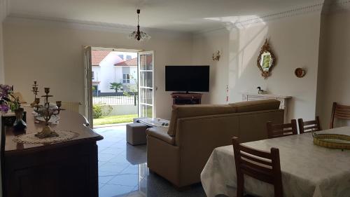 a living room with a couch and a table and a television at Villa spacieuse proche de L'océan in Vila Praia de Âncora