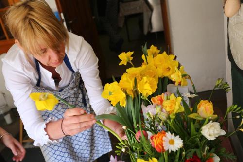 a woman is making a bouquet of flowers at Bräustüberl Schönbrunn in Wunsiedel