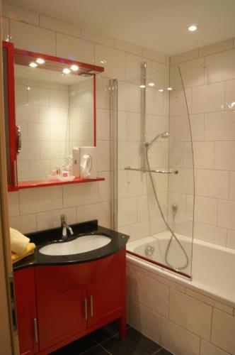 a bathroom with a sink and a shower and a tub at Falkner Appartement Resort in Längenfeld