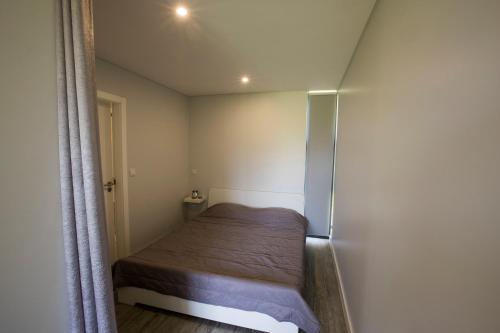 małą sypialnię z łóżkiem i lodówką w obiekcie Casa da Bi w mieście Arcos de Valdevez