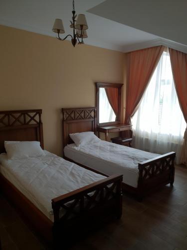 two beds in a room with two windows at Pride in Tarashcha