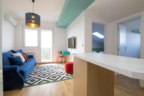 a kitchen and living room with a blue couch at Lola Almost Home in Belgrade