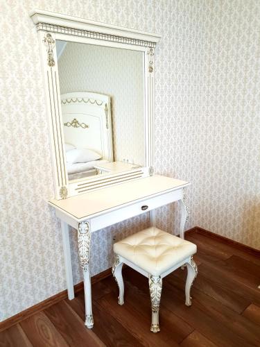 a white dressing table with a mirror and a stool at Pride in Tarashcha