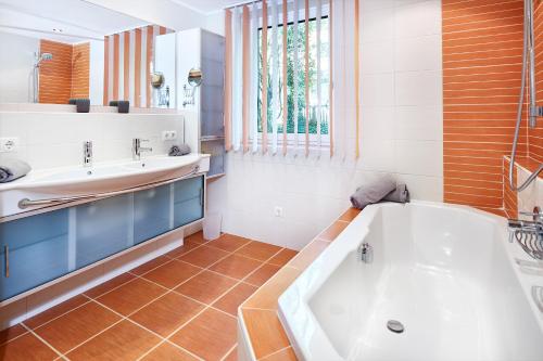 ein Badezimmer mit einer Badewanne und einem Waschbecken in der Unterkunft Apartments Radstadt in Radstadt