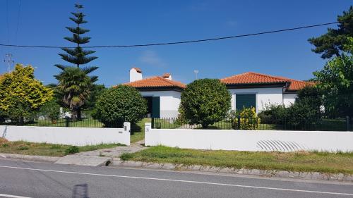 a white fence in front of a house at Villa spacieuse proche de L'océan in Vila Praia de Âncora