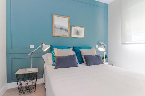 niebieska sypialnia z dużym łóżkiem z dwoma lampami w obiekcie COMFORT & STYLE IN MADRID!!! 3BD 2BTH+TERRACE w Madrycie