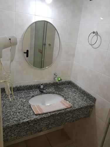 a bathroom with a sink and a mirror on a counter at Hotel Valle Sul in Registro