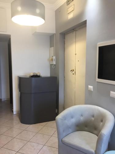 salon z krzesłem i telewizorem w obiekcie Bakirooms w Rzymie