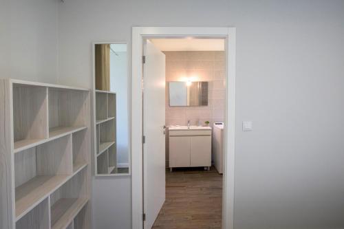 ein weißes Badezimmer mit Waschbecken und Spiegel in der Unterkunft Casa da Lo in Viana do Castelo