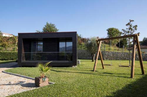 a black house with a playground and a swing at Casa da Lo in Viana do Castelo