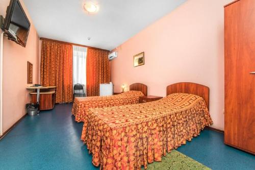 a hotel room with two beds and a television at Hotel Filton in Tyumen