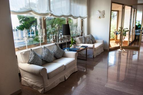 a living room with two couches and a large window at Grand Hotel Passetto in Ancona