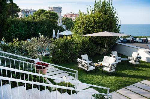 a balcony with chairs and a table and an umbrella at Grand Hotel Passetto in Ancona