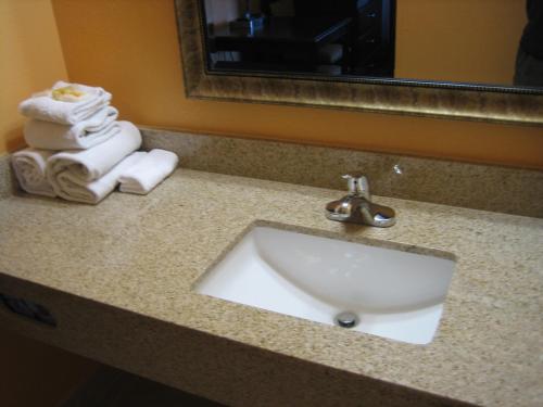 a bathroom sink with towels and a mirror at Days Inn by Wyndham Queensbury/Lake George in Queensbury