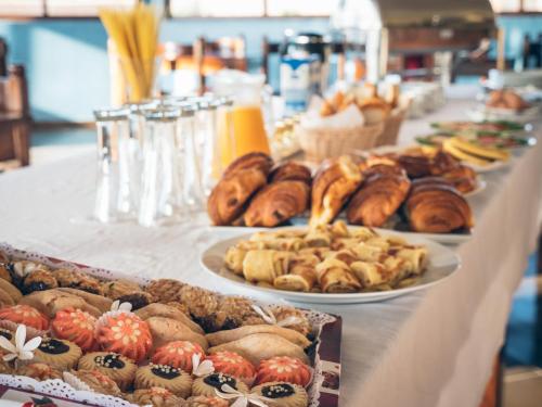 - une table avec plusieurs assiettes de pâtisseries et autres viennoiseries dans l'établissement Dakhla Kitesurf World, à Dakhla