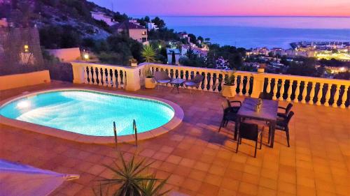 una piscina en un balcón con mesa y sillas en Ashram Villa Sunshine, en Sitges