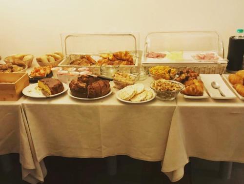 una mesa con muchos tipos diferentes de comida en ella en Agorà Hotel, en Calamandrana
