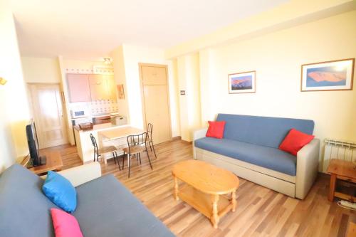 a living room with a blue couch and a table at Edificio san bernardo in Sierra Nevada