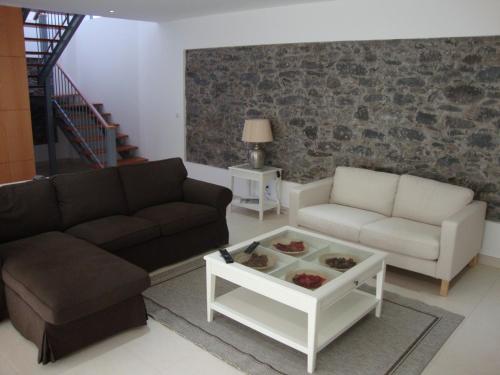 a living room with two couches and a coffee table at Casa da Praia in Calheta