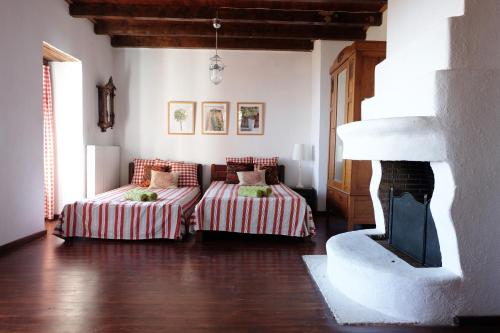 - un salon avec deux lits et une cheminée dans l'établissement Villa Pasithea, à Panteleímon