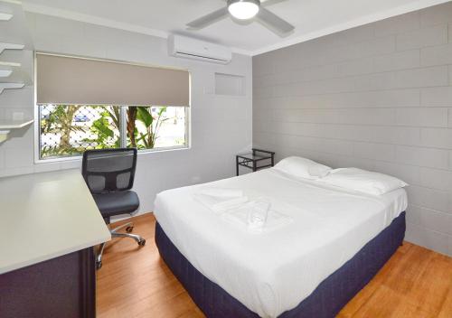 a bedroom with a bed and a desk and a chair at Cairns Student Lodge - ALL meals included in Smithfield