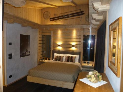 a bedroom with a large bed and a table at Albergo Chalet Lago Antorno in Misurina