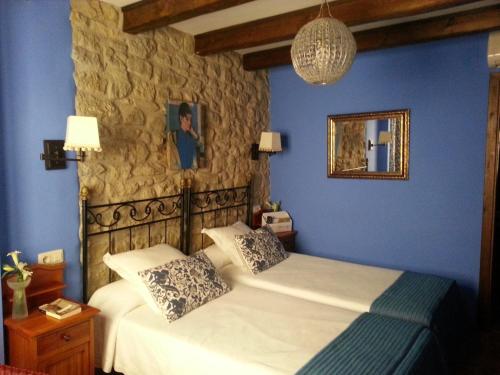 a blue bedroom with a bed and a mirror at Casa del Infanzón in Sos del Rey Católico