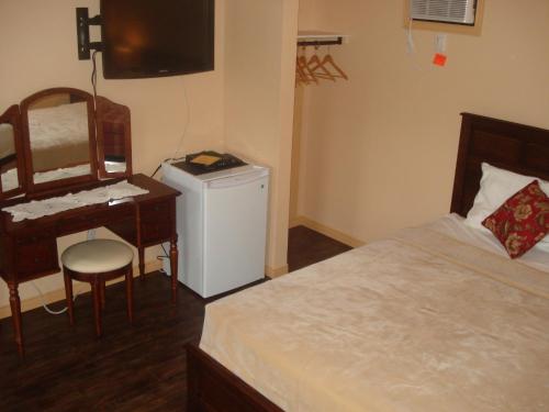 a bedroom with a bed and a desk and a computer at Motel la Maison de Travers in Baie-Sainte-Catherine