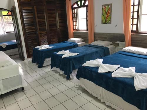 eine Gruppe von 4 Betten in einem Zimmer in der Unterkunft Marencanto Pousada in Ubatuba