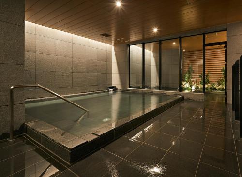 a swimming pool in a building with a pool at HATAGO INN Fukushima Hirono in Hirono