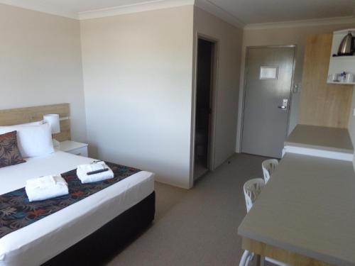 a hotel room with a bed and a desk at Castle Crest Motel in Townsville