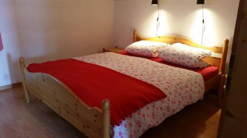 een slaapkamer met een houten bed met 2 kussens bij Barlangia (253 Ho) in Valbella