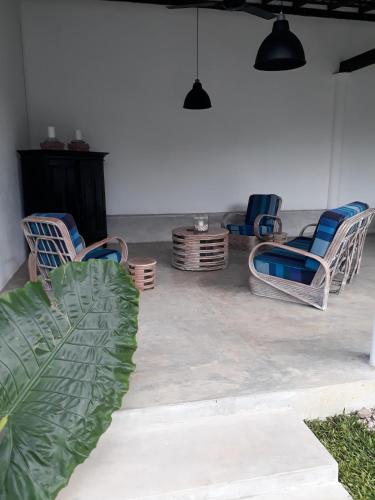 a living room with chairs and a table at South House-Weligama in Weligama
