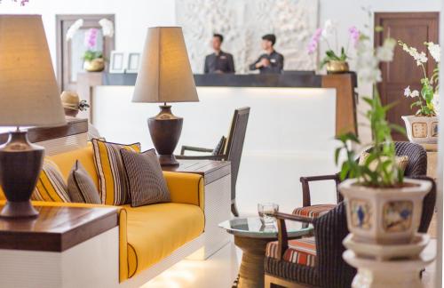 a living room with a yellow couch and chairs at Siam Bayshore Resort Pattaya in Pattaya South