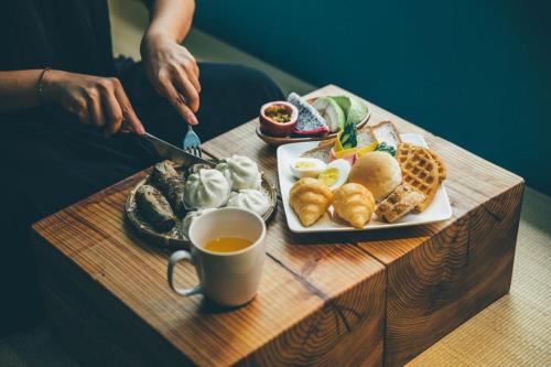 a table with a plate of food and a cup of coffee at Star Hostel Taipei East in Taipei