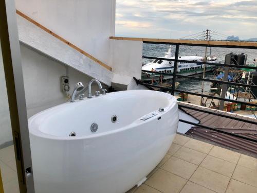 a bath tub in a room with a view of the water at The Wharf in Semporna